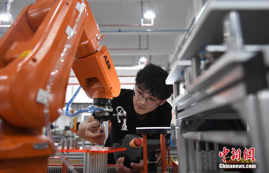 资料图：一家机器人生产企业的工作人员在调试机器人设备。 <a target='_blank' href='http://www.chinanews.com/'>中新社</a>记者 王刚 摄